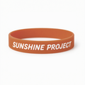 Orange wristband with 'SUNSHINE PROJECT' text on a white background