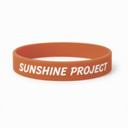 Orange wristband with 'SUNSHINE PROJECT' text on a white background