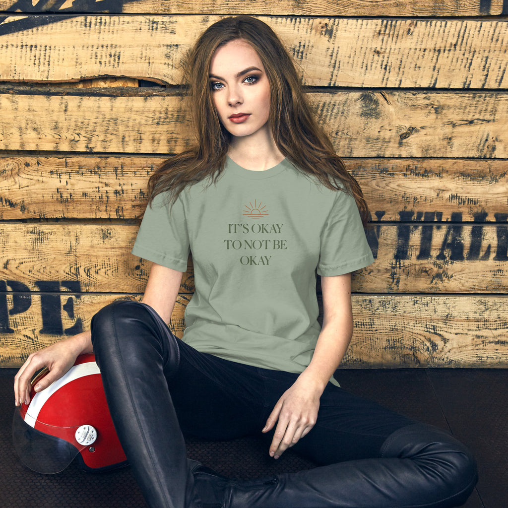 The Sunshine Project It's Okay to Not Be Okay tee in sage green, front view